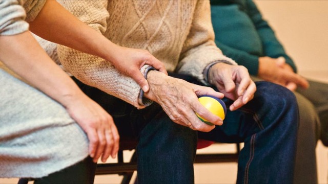 Jüngere Hand hält die Hand eines älteren Menschen